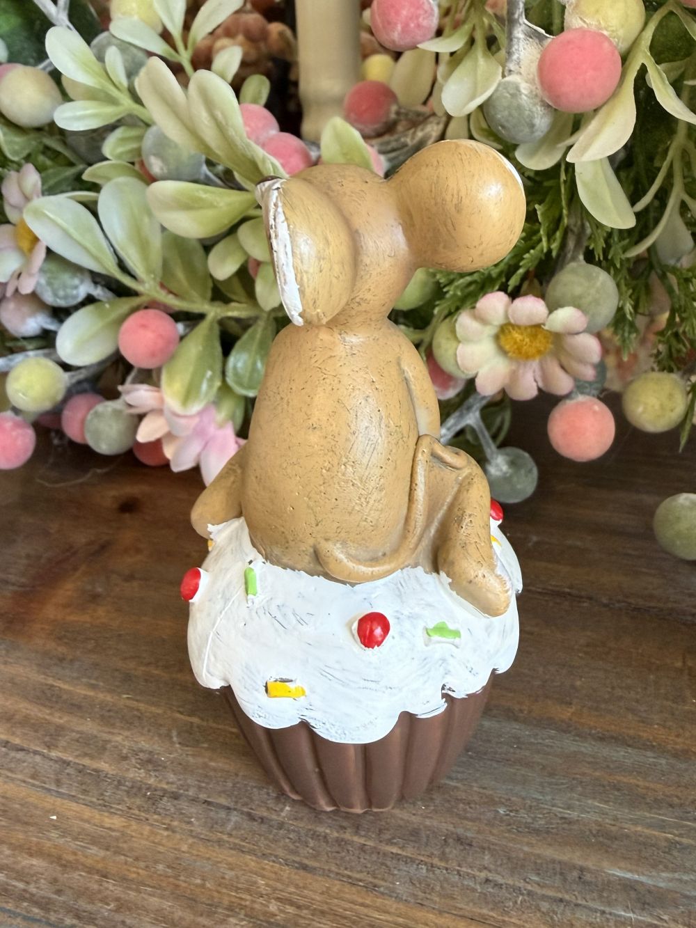 Figurine souris beige assise sur un cupcake blanc décoré, ambiance romantique shabby chic et décoration printanière pleine de charme