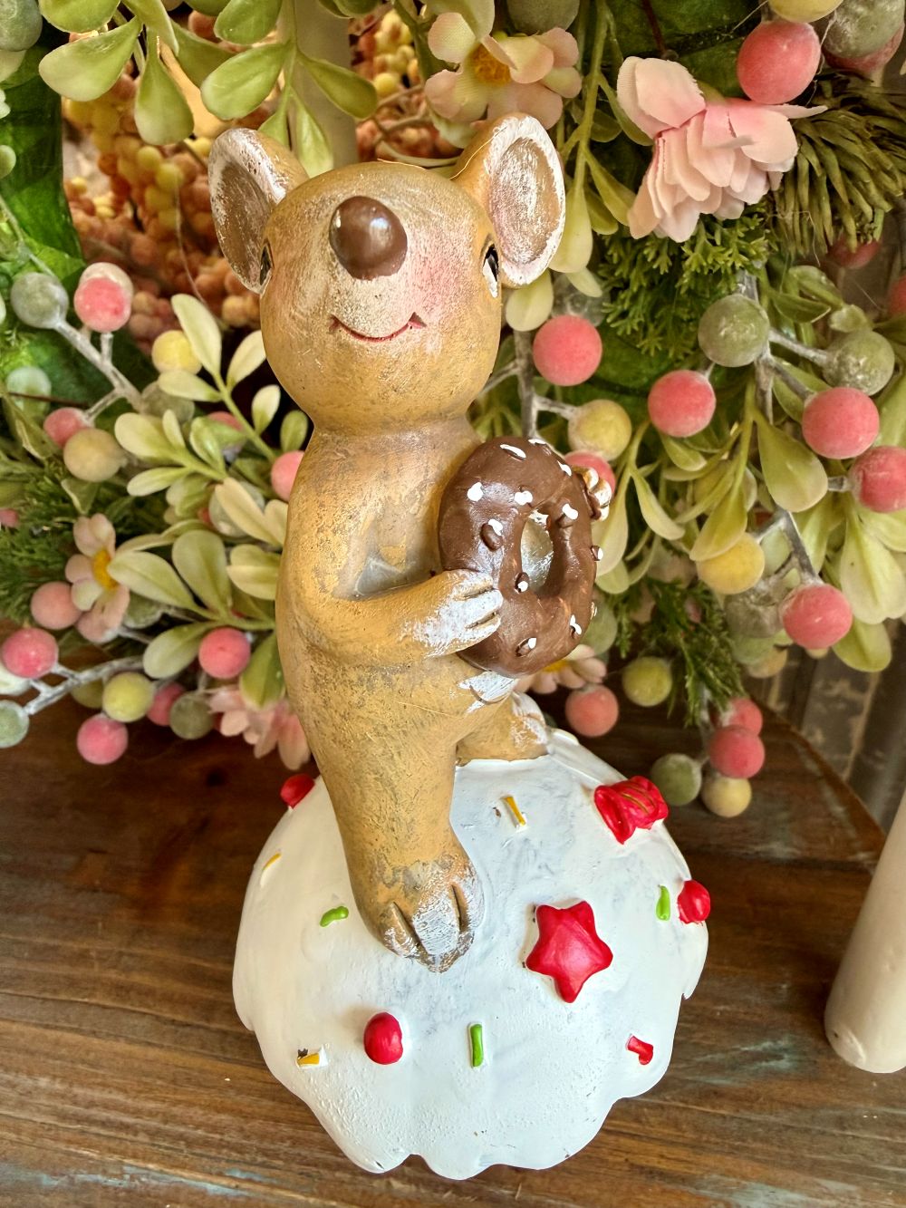 Figurine souris décorative tenant un donut chocolaté posée sur un gâteau blanc, style romantique shabby chic et décoration de charme
