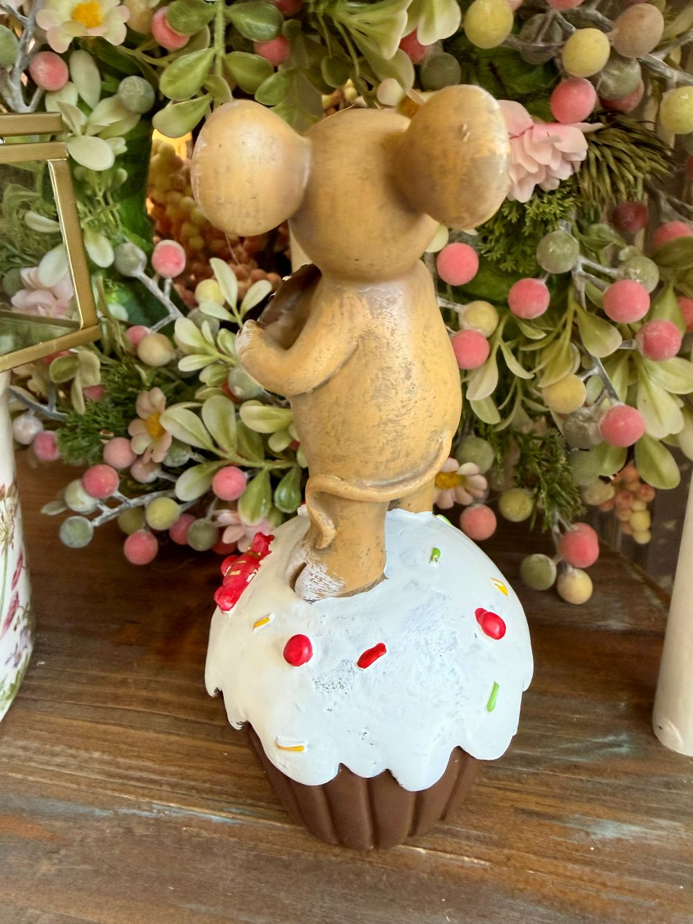 Figurine souris décorative tenant un donut chocolaté posée sur un gâteau blanc, style romantique shabby chic et décoration de charme