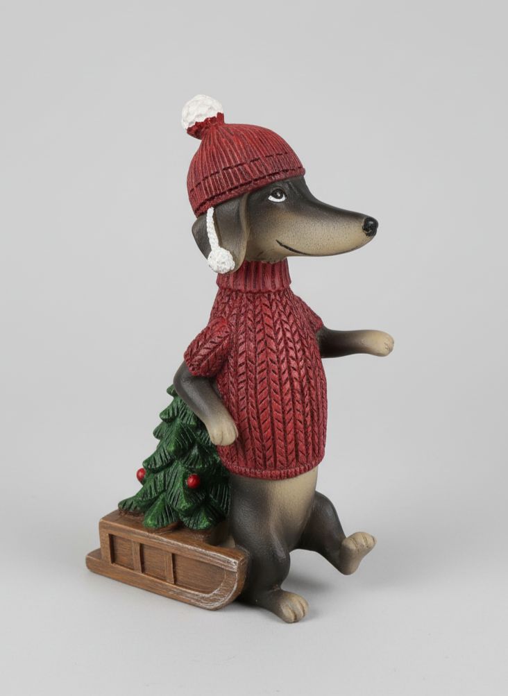 Figurine de teckel des neiges en pull rouge avec bonnet, accompagnée d’une luge et d’un petit sapin, style déco de Noël shabby chic et féérique