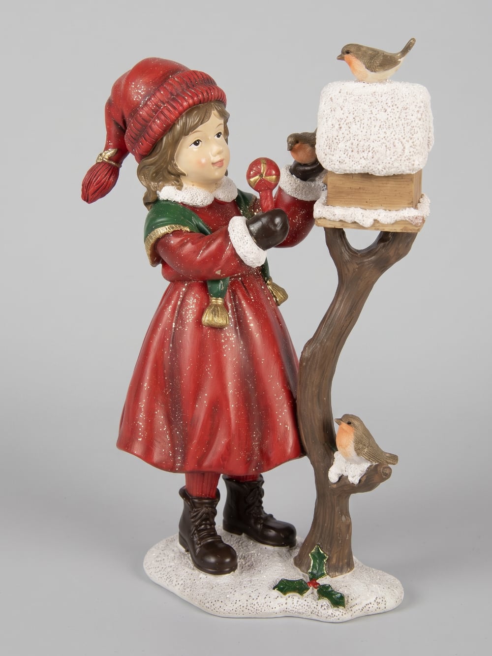 Figurine représentant une fillette en manteau rouge nourrissant des rouge-gorges près d'un nichoir enneigé, décoration de Noël romantique et poétique