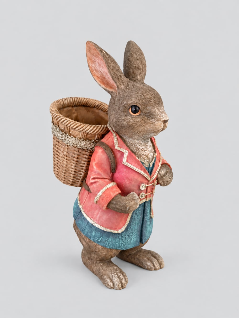 Grand lapin décoratif brun vêtu de rose et bleu avec panier dans le dos, style Alice romantique et décoration poétique de Pâques