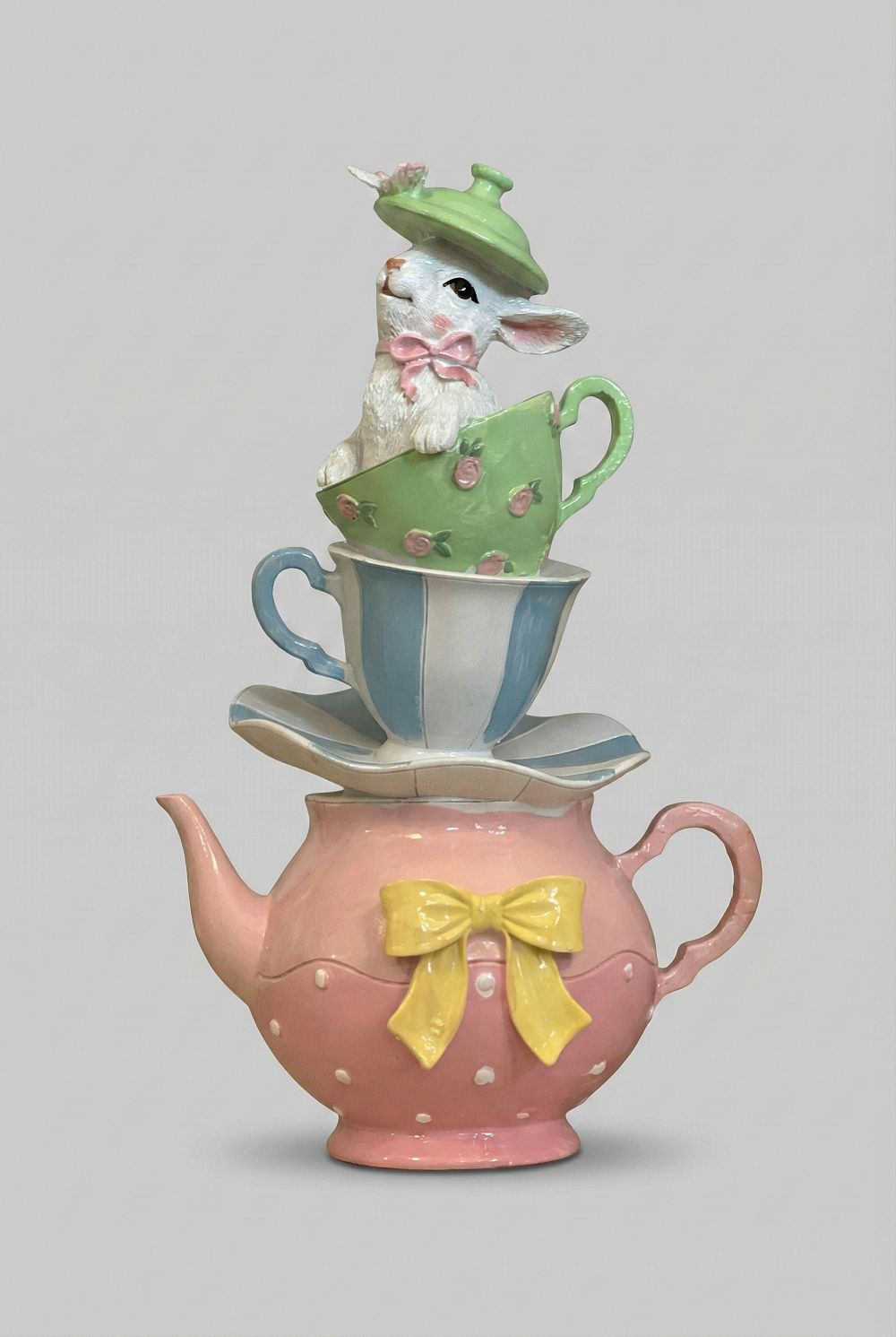 Grande théière décorative rose avec tasses empilées et lapin, tons pastel vert et bleu, style shabby chic romantique et féérique, décoration poétique de charme