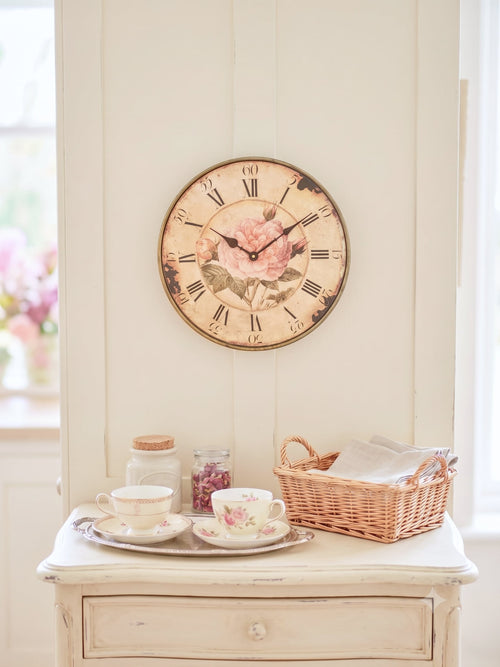 Horloge murale shabby chic avec rose ancienne rose poudré, cadran patiné style vintage et chiffres romains noirs pour décoration romantique de charme