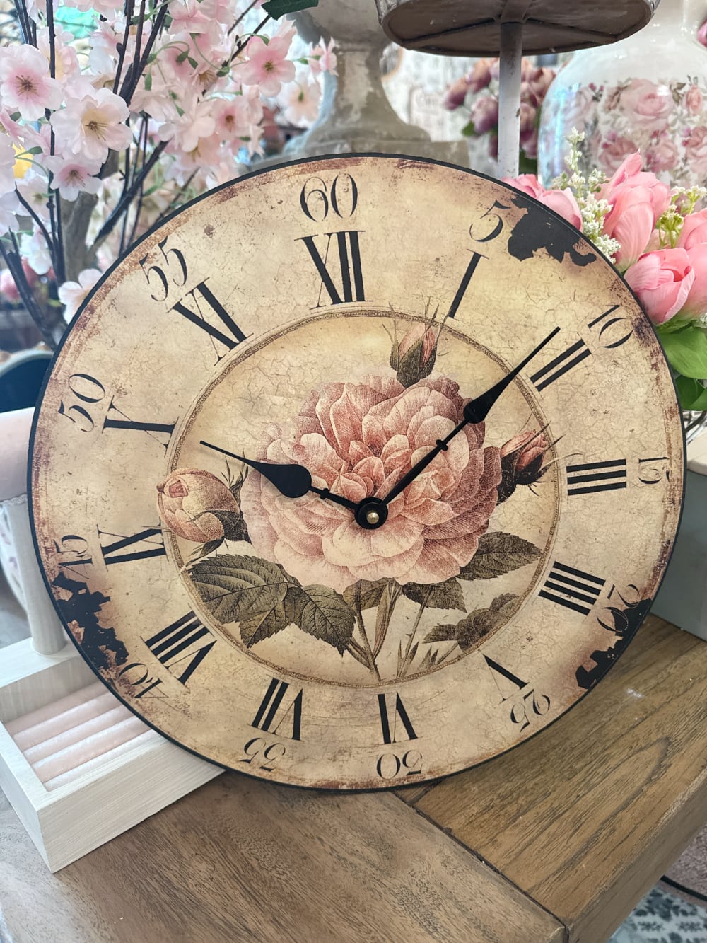 Horloge murale shabby chic avec rose ancienne rose poudré, cadran patiné style vintage et chiffres romains noirs pour décoration romantique de charme
