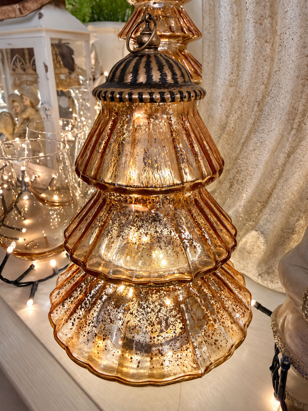 Lanterne sapin de Noël en verre ambré aux reflets dorés et finition patinée, décoration lumineuse chaleureuse et féérique