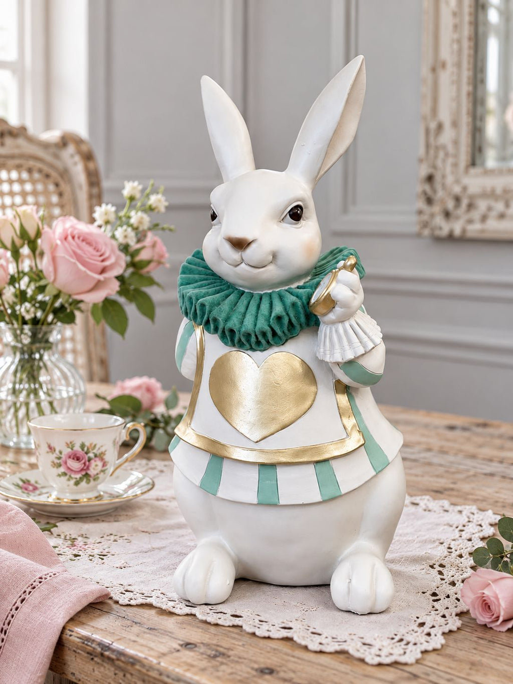 Le Fabuleux Lapin d’Alice sur une table ancienne, accompagné d’une tasse fleurie et de roses roses dans une ambiance de goûter romantique.