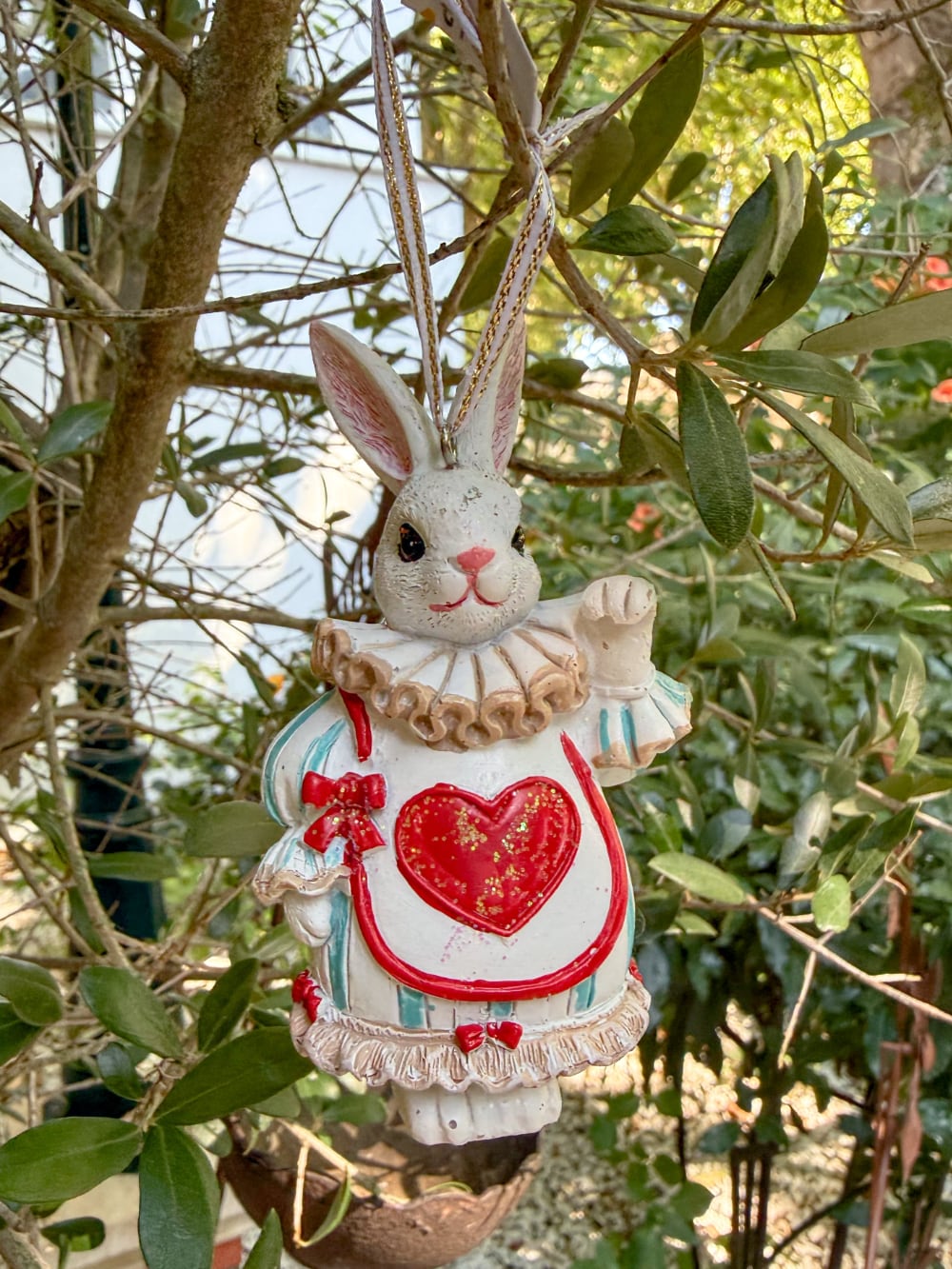 Figurine lapin à suspendre inspirée d'Alice au Pays des Merveilles, avec collerette, tablier à cœur rouge et ruban, idéale pour une décoration de Pâques ou de Noël