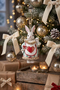 Figurine lapin à suspendre inspirée d'Alice au Pays des Merveilles, avec collerette, tablier à cœur rouge et ruban, idéale pour une décoration de Pâques ou de Noël