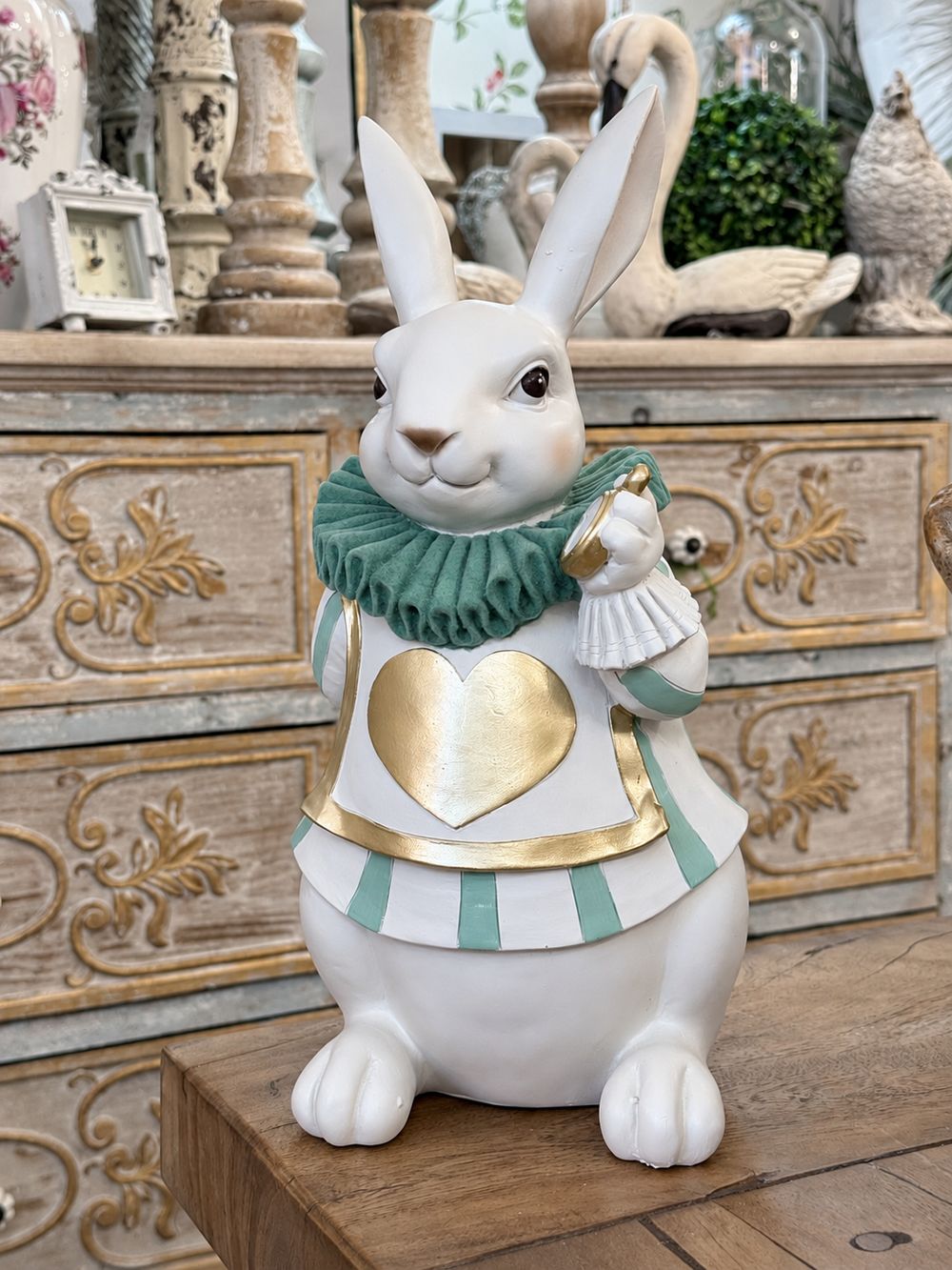 Le Fabuleux Lapin d’Alice vu de face, avec son col vert, son cœur doré et sa montre.