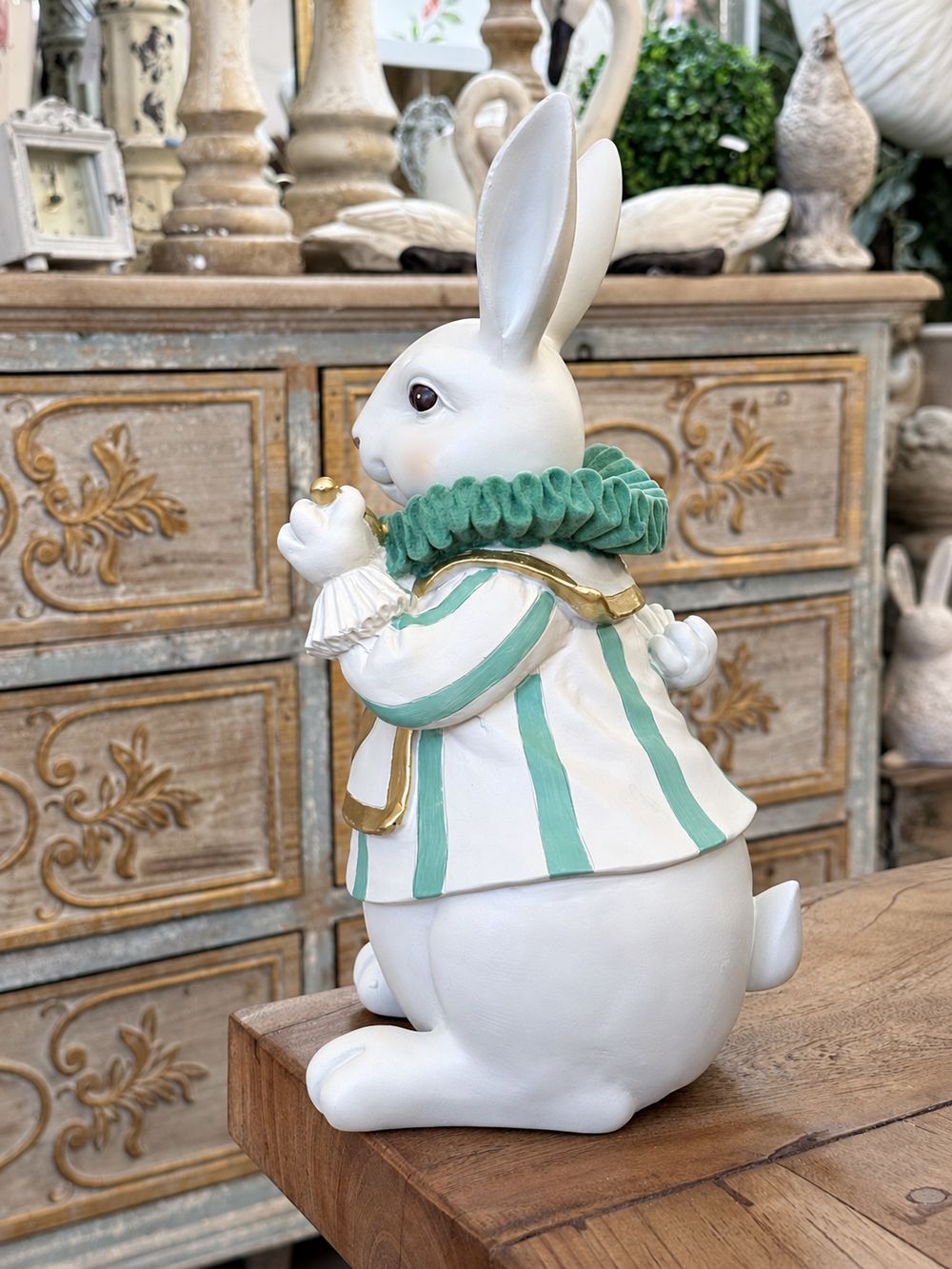 Vue de profil du Fabuleux Lapin d’Alice, avec son col plissé vert et ses finitions dorées.