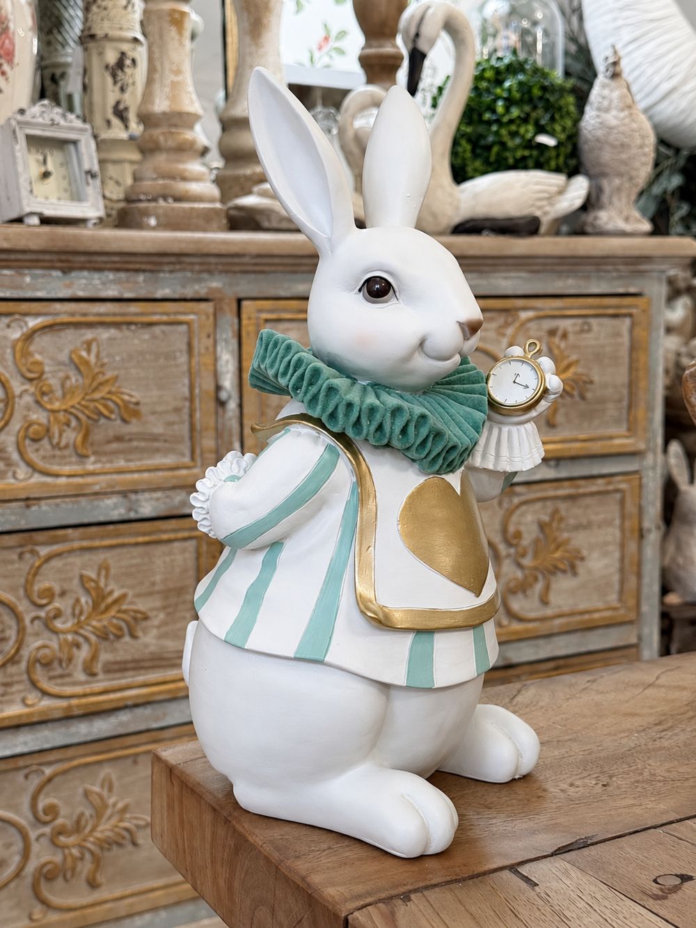 Le Fabuleux Lapin d’Alice vu de trois quarts, montrant sa montre et son costume rayé vert et blanc.