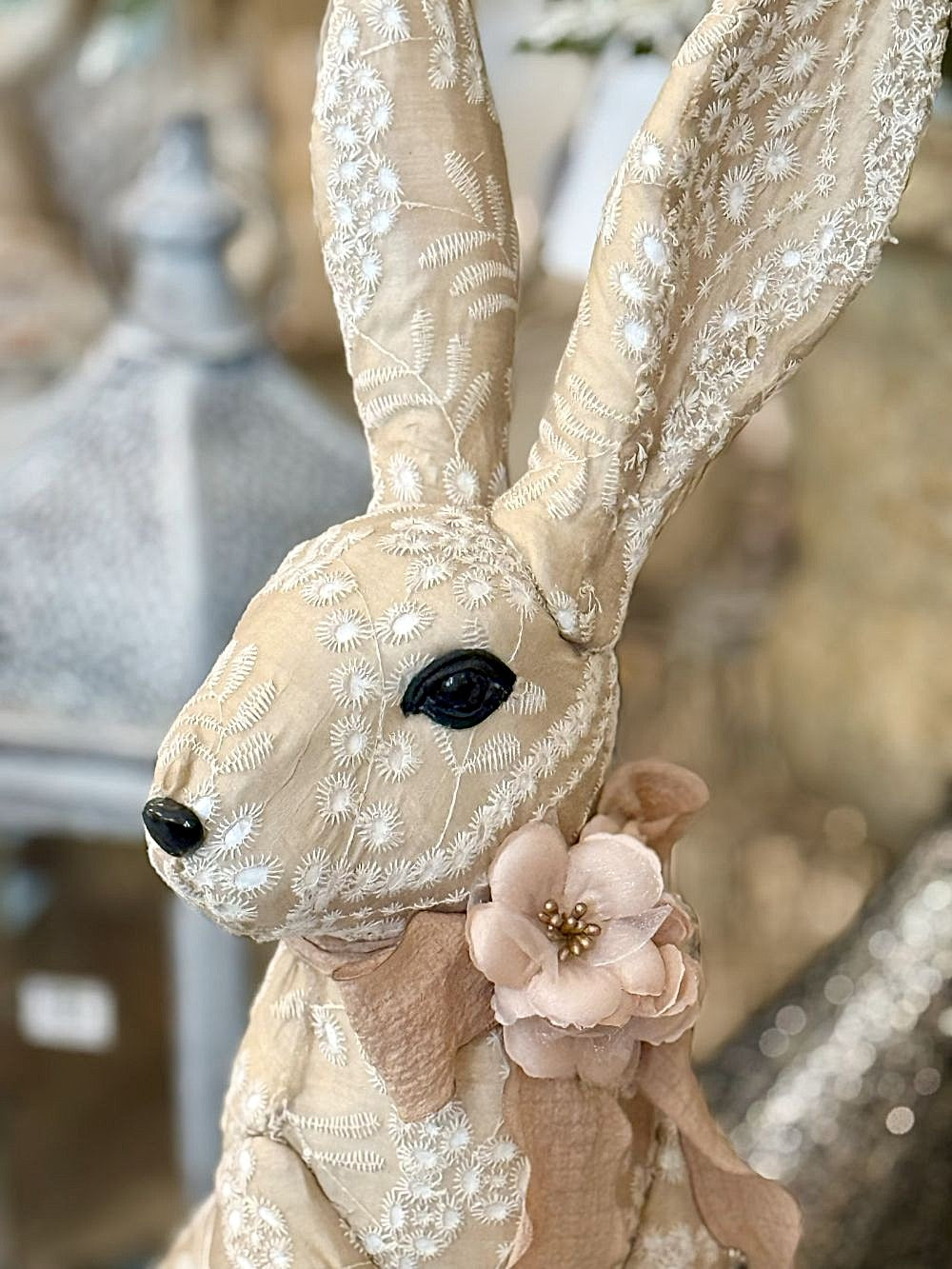 Lapin décoratif en tissu brodé beige et blanc avec fleur rose, style shabby chic et romantique, idéal pour une décoration poétique et féérique.