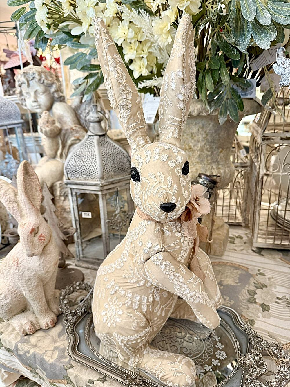 Lapin décoratif en tissu brodé beige et blanc avec fleur rose, style shabby chic et romantique, idéal pour une décoration poétique et féérique.
