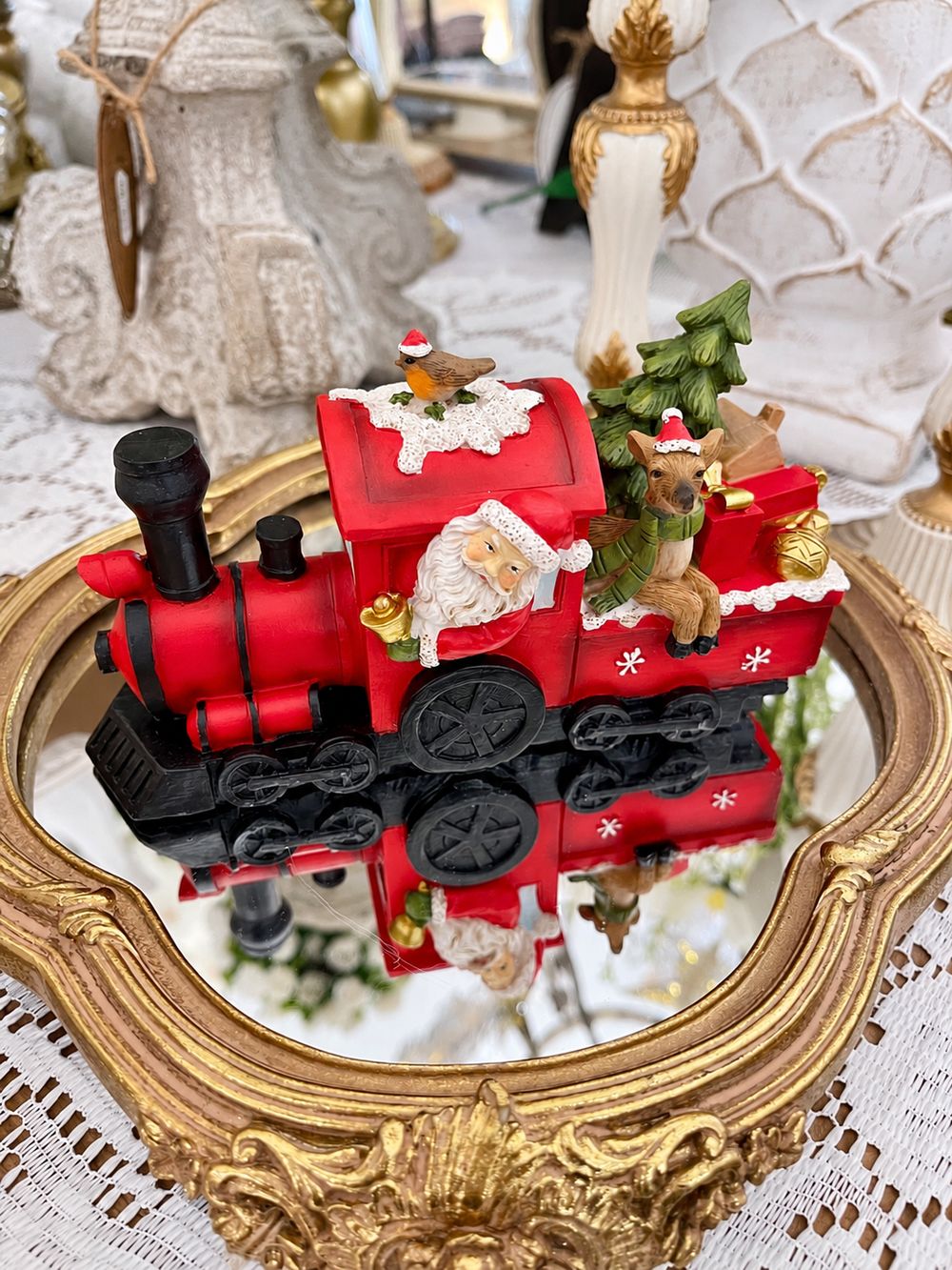 Vue de face de la locomotive de Noël rouge avec Père Noël et renne, sur un plateau miroir.