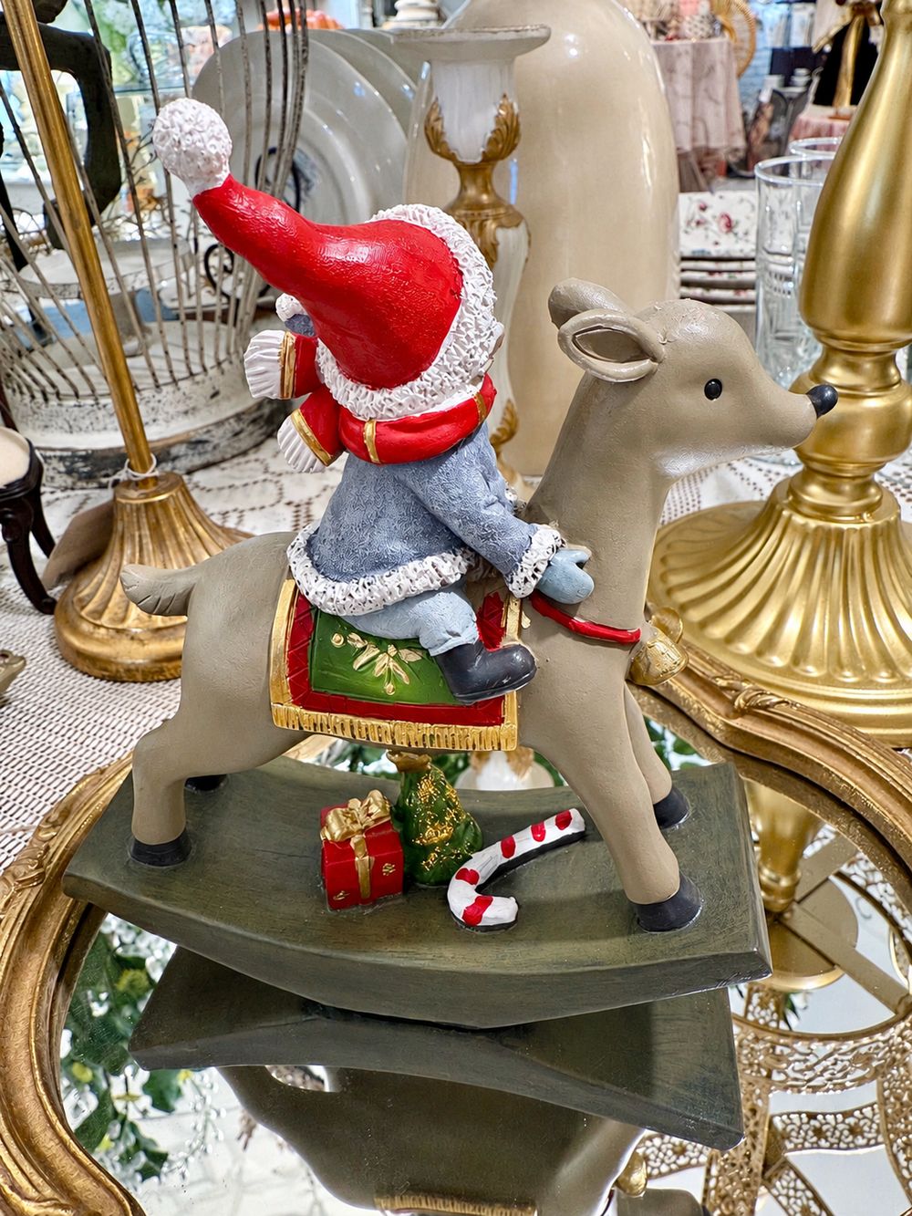 Vue arrière de la figurine Lutin Joyeux à Dos de Renne, montrant le bonnet rouge et le tapis de selle vert et doré.