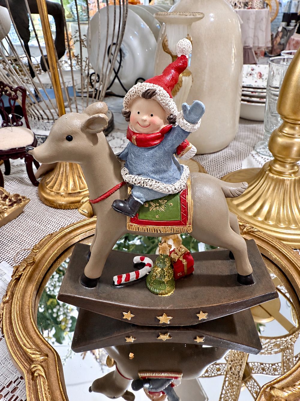 Figurine de Noël Lutin Joyeux à Dos de Renne vue de profil, avec sapin miniature, cadeau et sucre d’orge sur son socle.
