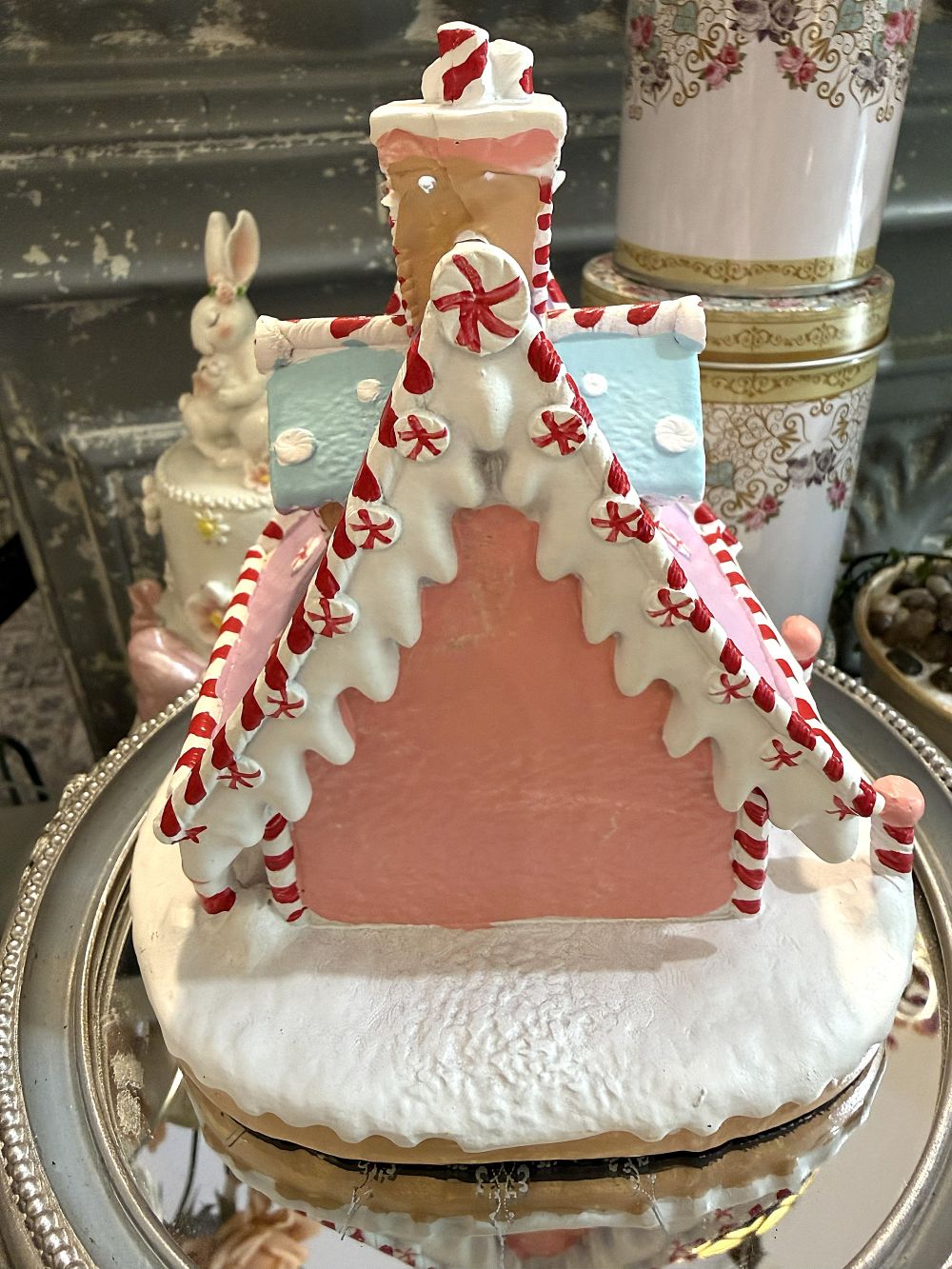 Maisonnette pain d’épice décorative de Noël rose pastel, blanche et bleu ciel, avec décor enneigé et bonhomme de neige, pour ambiance de Noël féérique