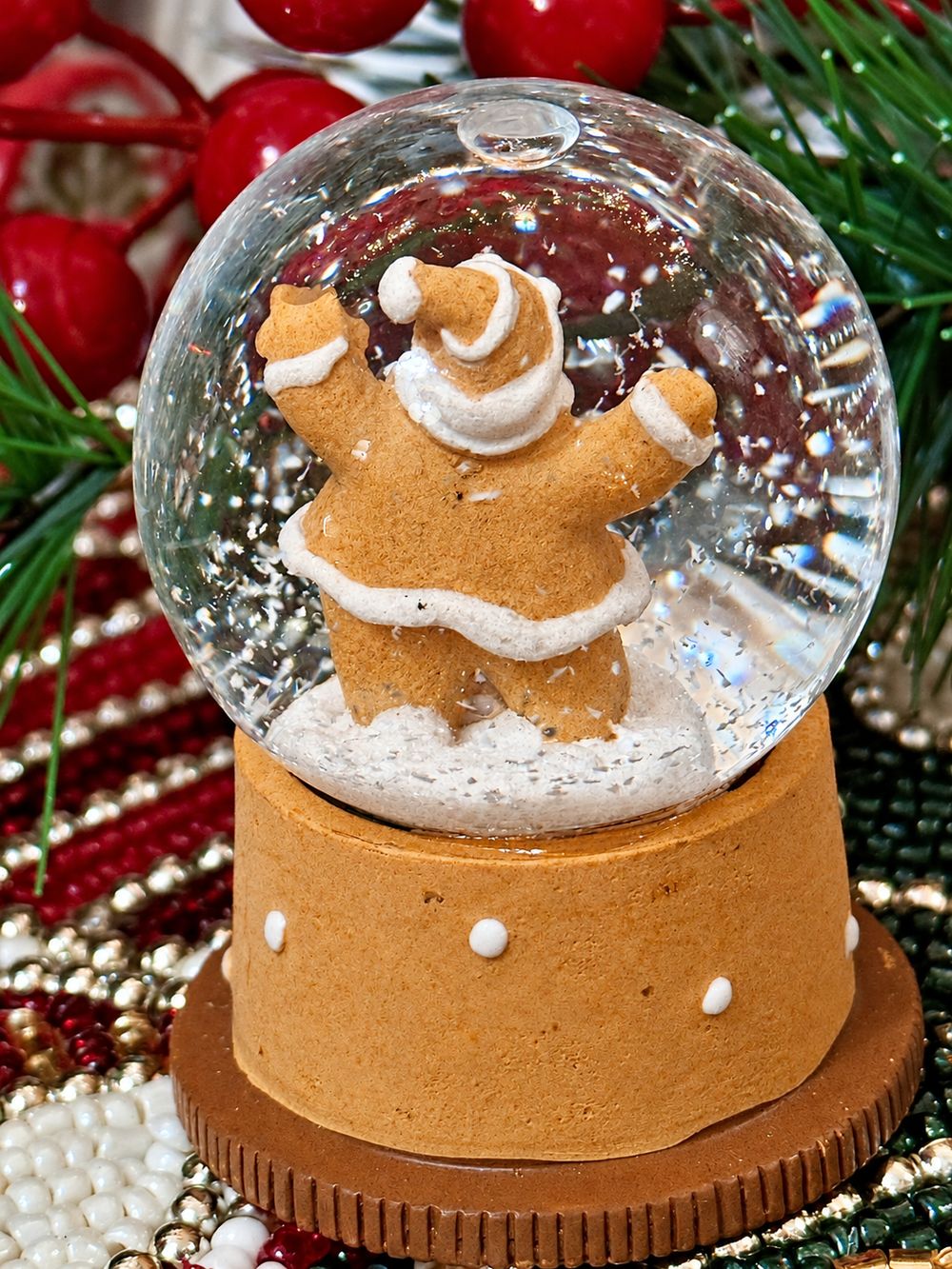Vue de dos de la mini boule à neige Père Noël Pain d’Épices et de son socle doré.