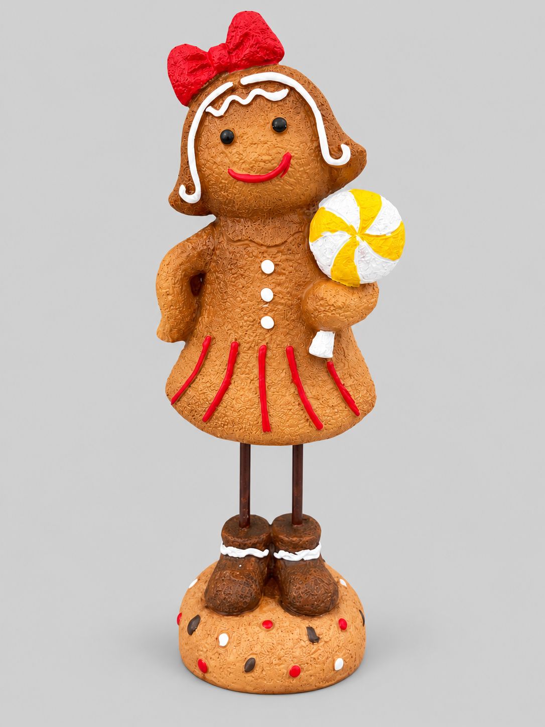 Figurine Mme Gingerman avec nœud rouge et sucette jaune et blanche, présentée de face sur fond gris clair.