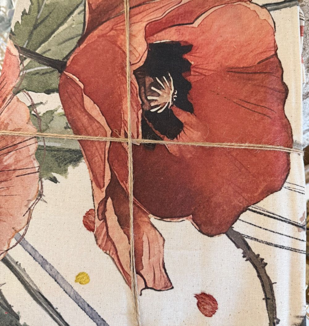 Nappe enduite Blanc Mariclò à motifs coquelicots rouges et verts sur fond écru, textile de table romantique au style shabby chic et campagne.