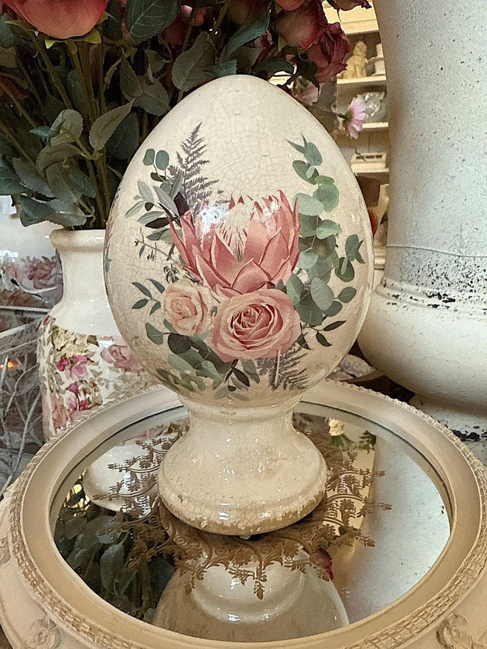 Œuf décoratif aux roses sur pied en terre cuite, blanc patiné avec fleurs roses et feuillage vert, style shabby chic et décoration romantique printanière