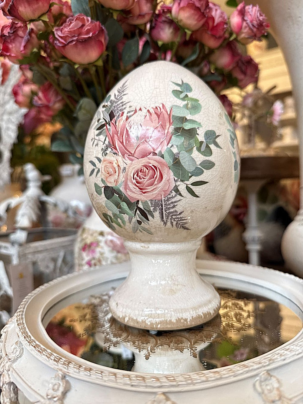 Œuf décoratif aux roses sur pied en terre cuite, blanc patiné avec fleurs roses et feuillage vert, style shabby chic et décoration romantique printanière