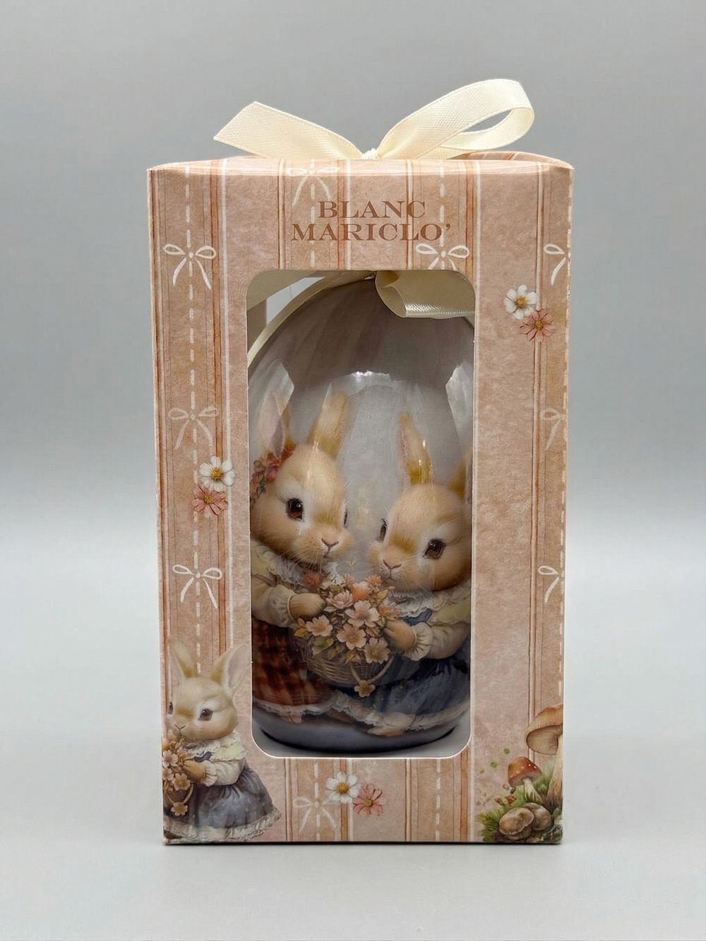 Œuf décoratif romantique Blanc Mariclò avec illustration de lapins tenant des fleurs, tons blanc beige et rose poudré, ambiance shabby chic et décoration de charme printanière