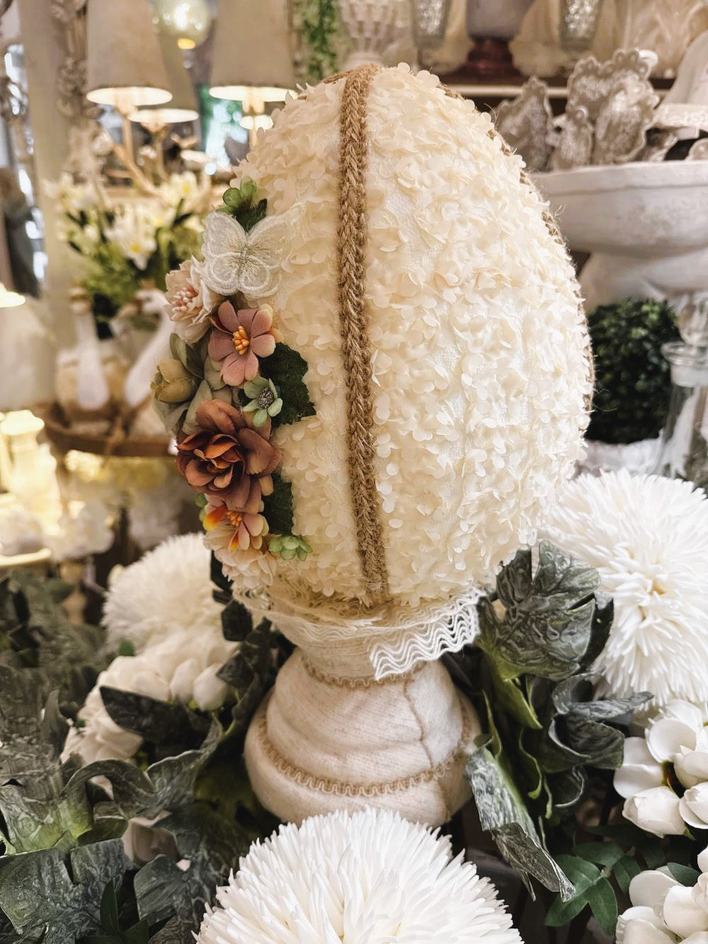 Œuf décoratif en style shabby chic orné de fleurs en tissu et de papillons, dans les tons ivoire, vieux rose et vert sauge, pour une ambiance romantique et poétique.