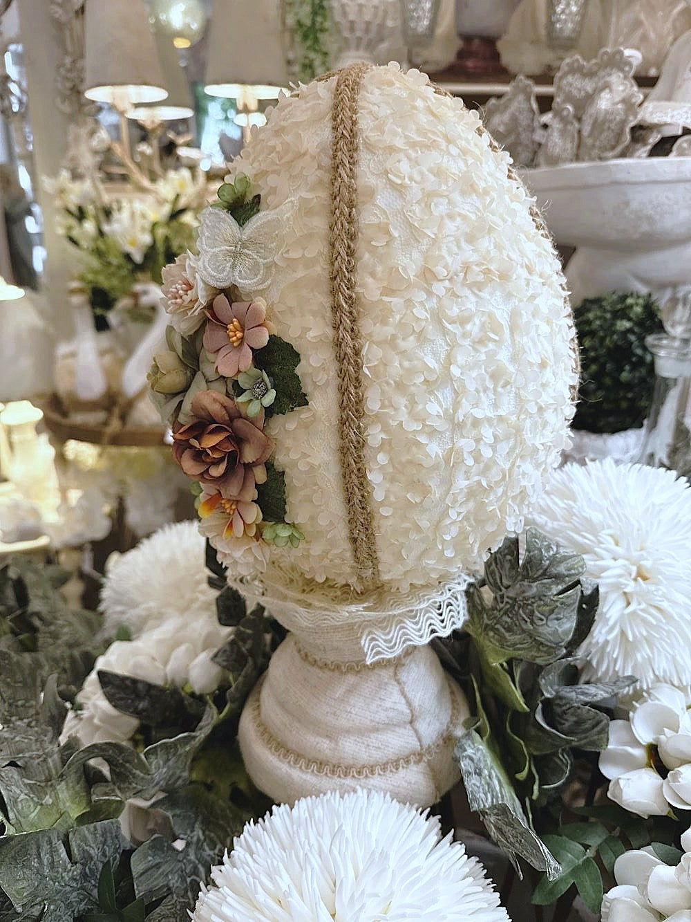 Œuf décoratif en style shabby chic orné de fleurs en tissu et de papillons, dans les tons ivoire, vieux rose et vert sauge, pour une ambiance romantique et poétique.