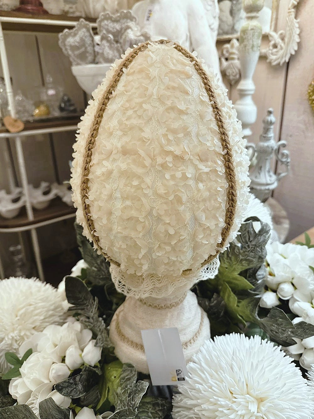 Œuf décoratif en style shabby chic orné de fleurs en tissu et de papillons, dans les tons ivoire, vieux rose et vert sauge, pour une ambiance romantique et poétique.