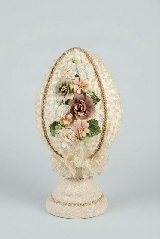 Œuf décoratif en style shabby chic orné de fleurs en tissu et de papillons, dans les tons ivoire, vieux rose et vert sauge, pour une ambiance romantique et poétique.