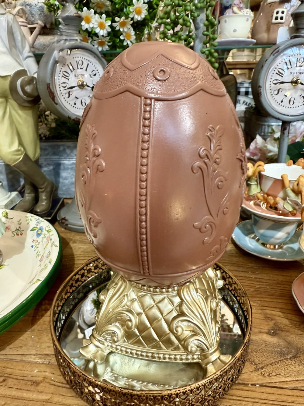 Œuf de Pâques décoratif sur piédestal doré, coloris brun et beige, avec relief de lapin fleuri, idéal pour une décoration de charme romantique et printanière sur une table, un buffet ou une console