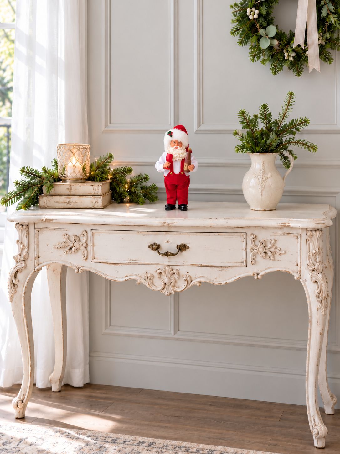 Petite figurine Père Noël Esprit des Vignes sur une console blanche ancienne, dans un décor de Noël lumineux.