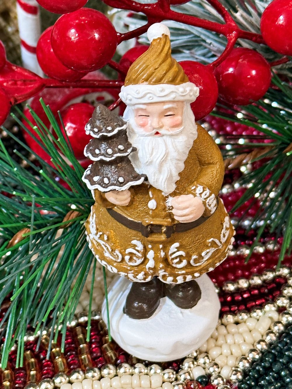 Vue rapprochée du Père Noël Pain d’Épices Miniature et de ses ornements blancs.