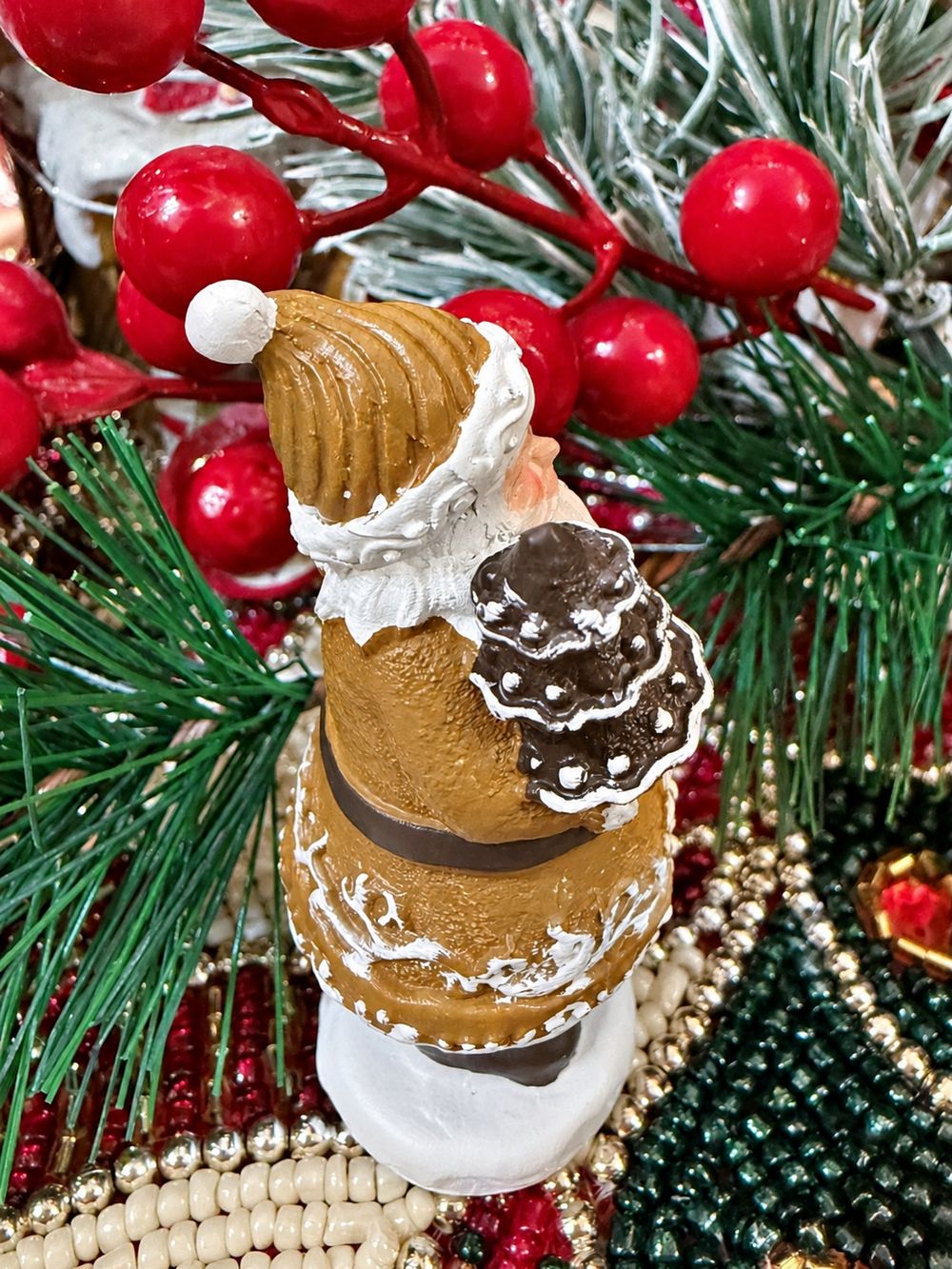 Vue de profil du Père Noël Pain d’Épices Miniature tenant son petit sapin.