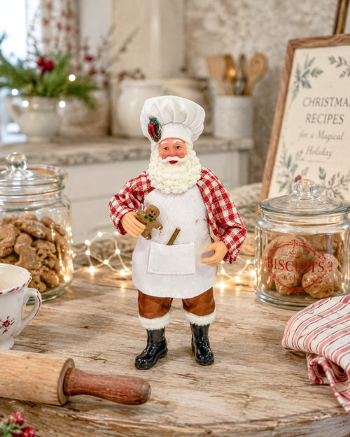 Père Noël Patissier rouge et blanc avec toque de chef, tablier et petit bonhomme en pain d’épices, figurine décorative pour cuisine de Noël