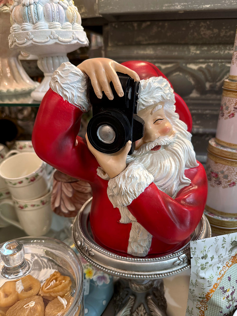 Figurine Père Noël photographe posée sur un présentoir dans la boutique