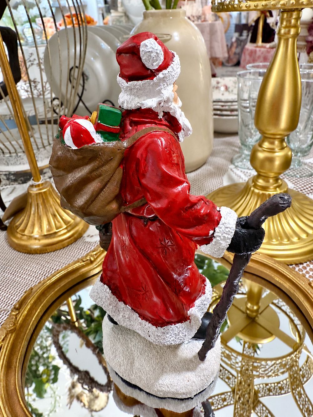Vue de profil du Père Noël Randonnée, avec sa hotte de cadeaux et son bâton.