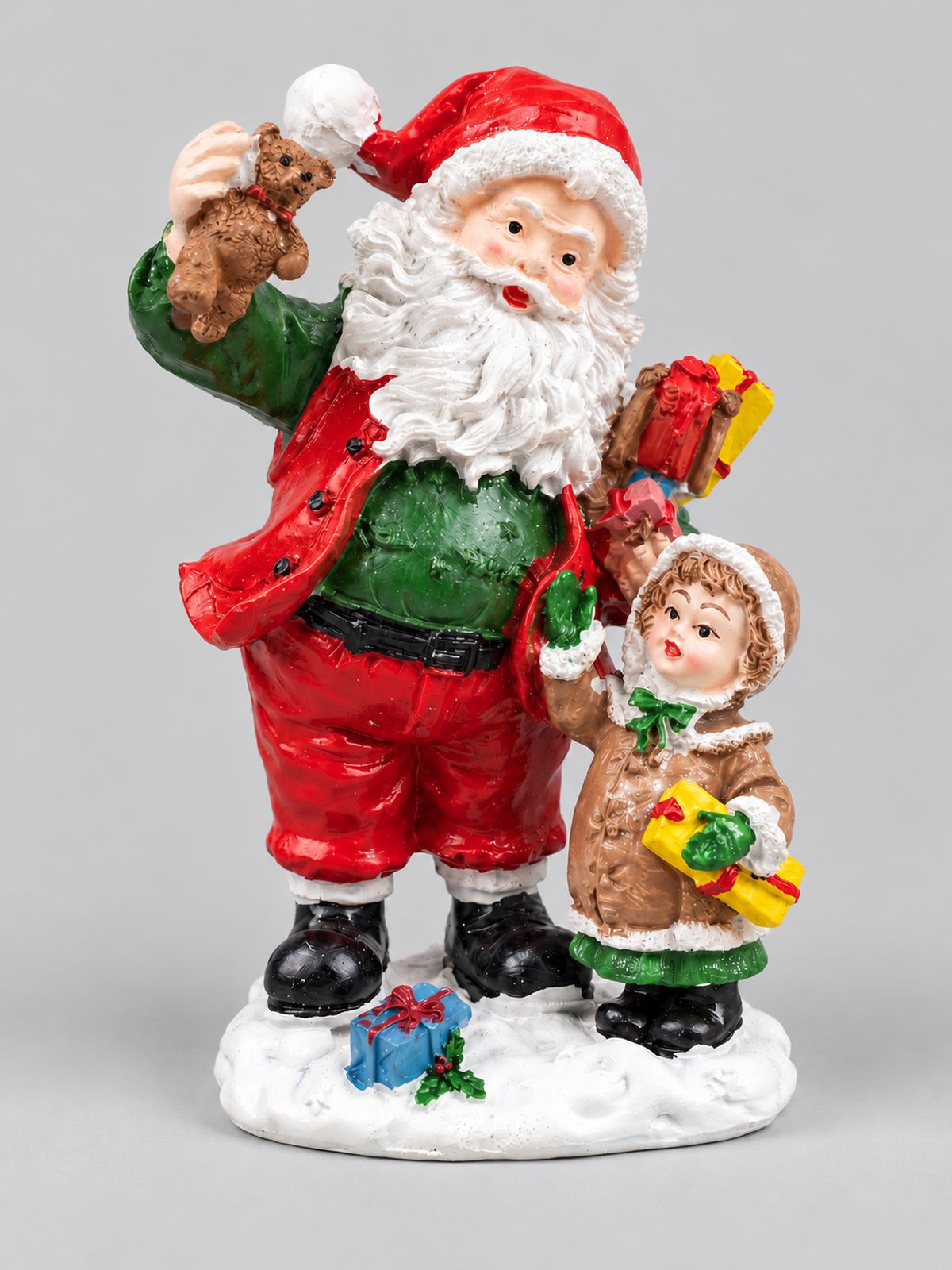 Figurine Père Noël et enfant avec ourson et cadeaux, présentée de face sur fond gris clair.