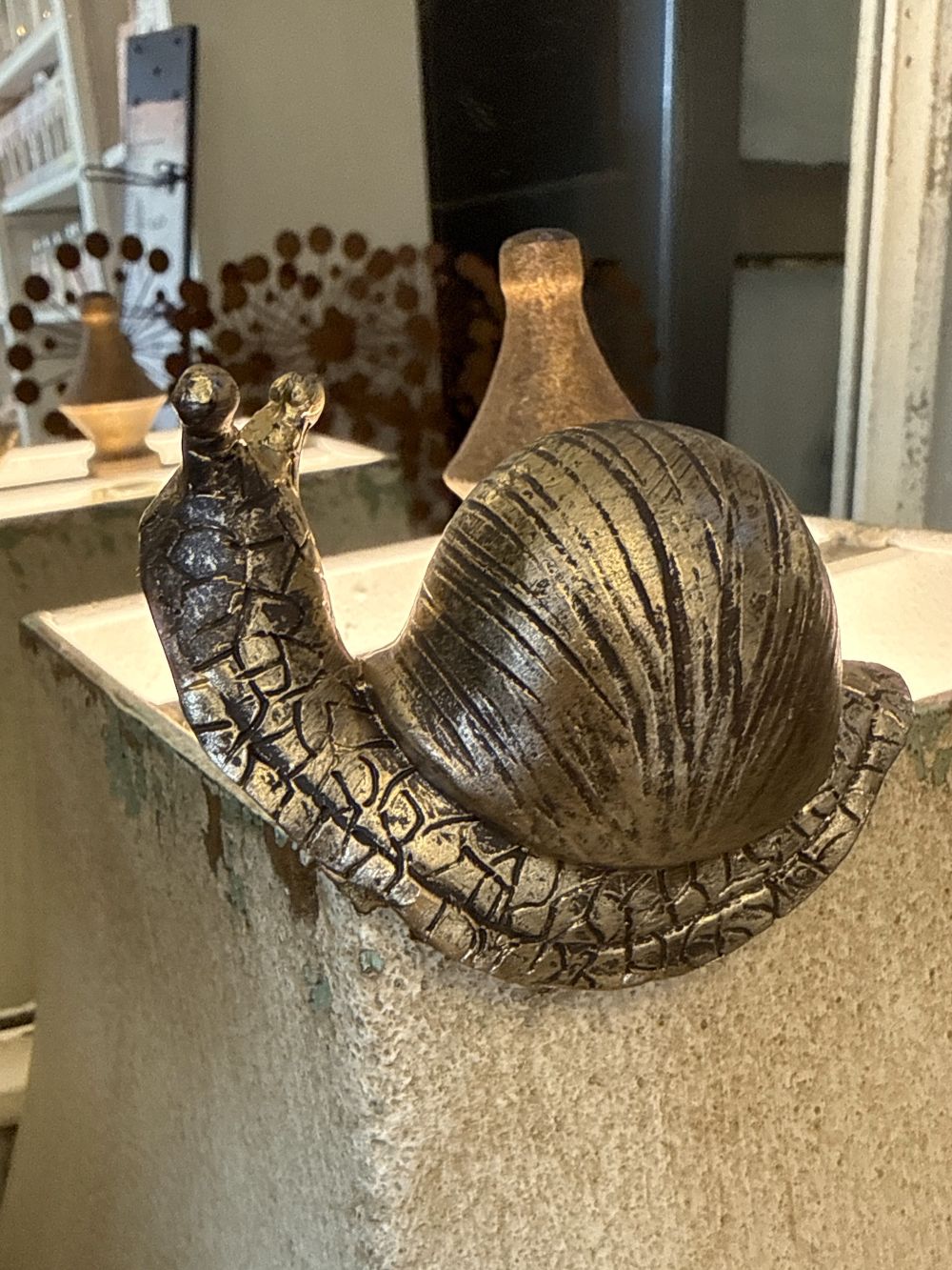 Petit escargot grimpeur décoratif doré patiné, figurine shabby chic de charme, accroché au rebord d’un pot dans une ambiance poétique