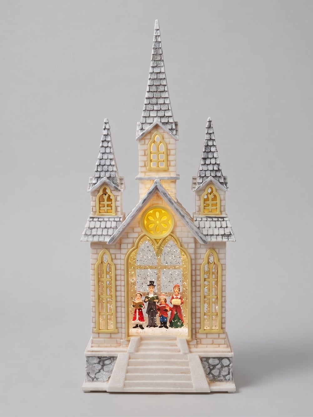 Chapelle de Noël lumineuse avec chorale miniature, éclairage chaleureux et paillettes animées, décoration féérique de village de Noël romantique