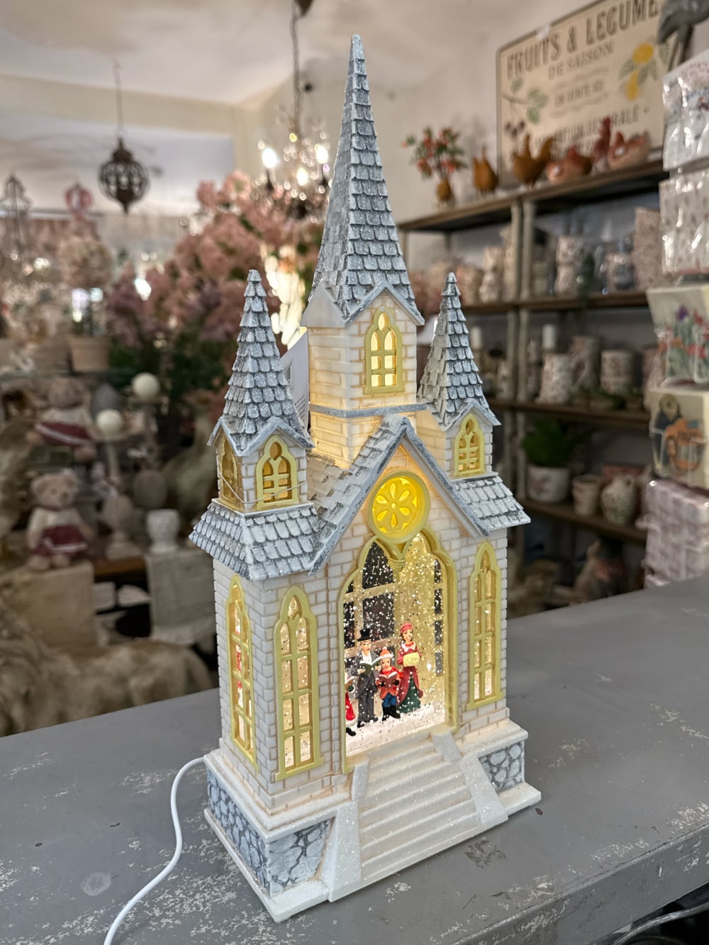 Chapelle de Noël lumineuse avec chorale miniature, éclairage chaleureux et paillettes animées, décoration féérique de village de Noël romantique