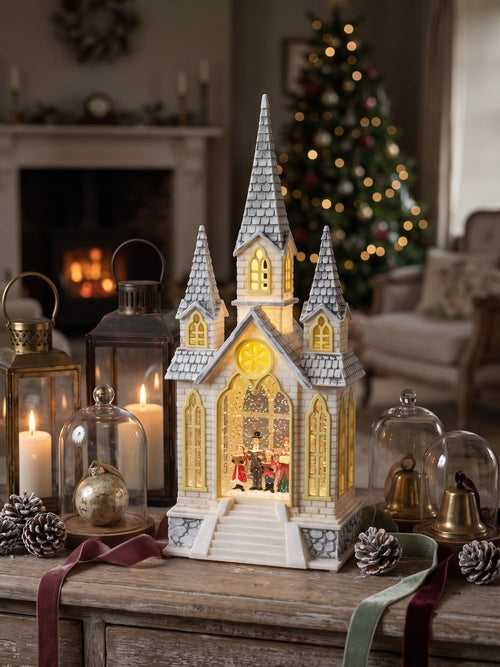 Chapelle de Noël lumineuse avec chorale miniature, éclairage chaleureux et paillettes animées, décoration féérique de village de Noël romantique