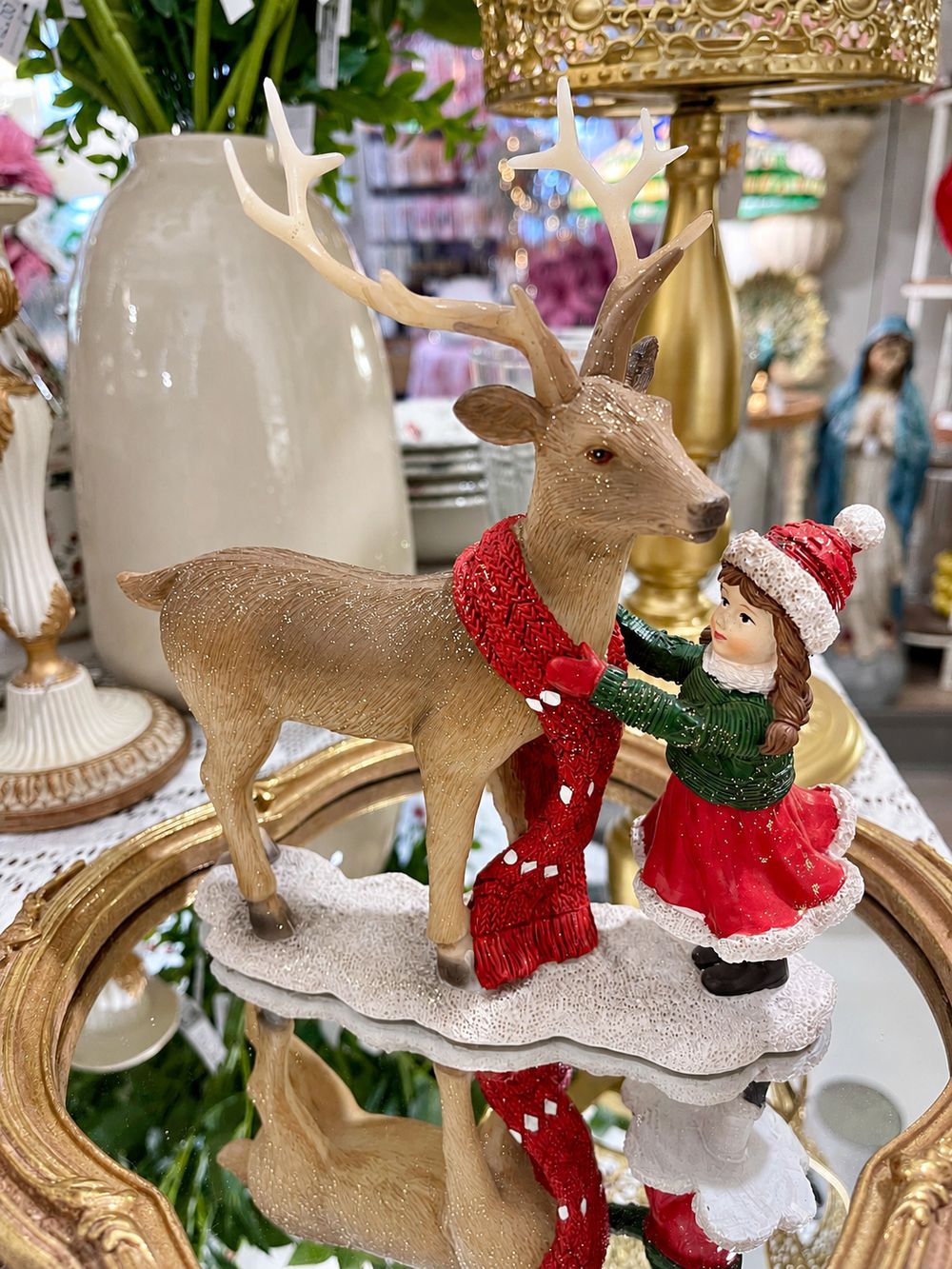 Figurine Petite Fille et Son Cerf de 21 cm, vue de face sur son socle enneigé.