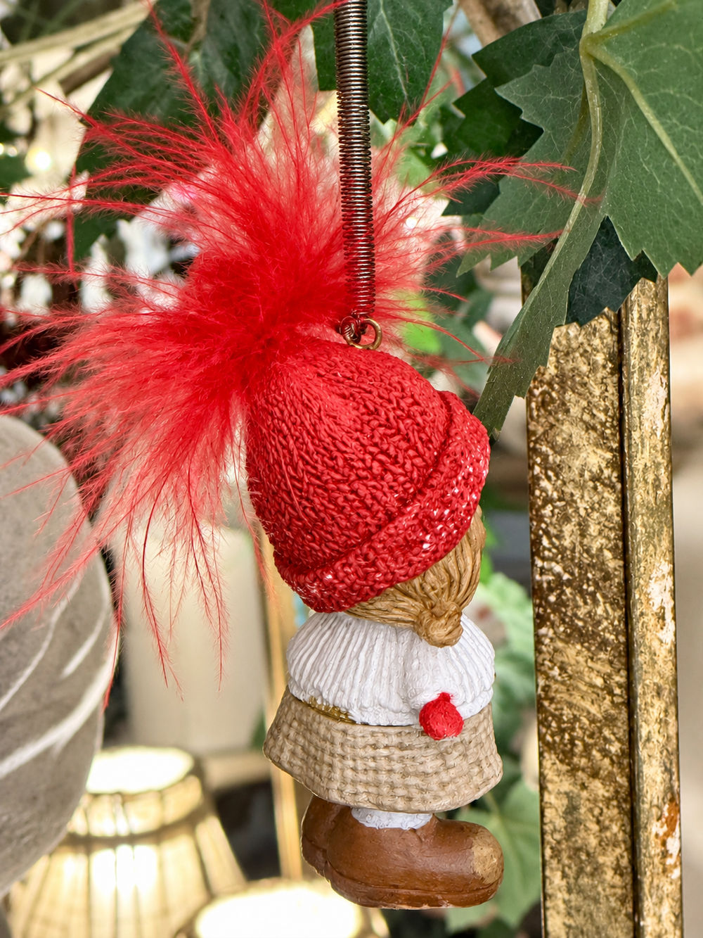 Petite fille de Noël sur ressort vue de dos avec bonnet rouge et tenue blanche et beige
