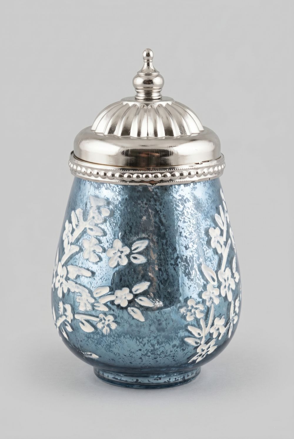 Petite lanterne LED bleue en verre avec motifs floraux en relief et couvercle argenté en métal, décoration romantique et shabby chic pour une ambiance lumineuse chaleureuse