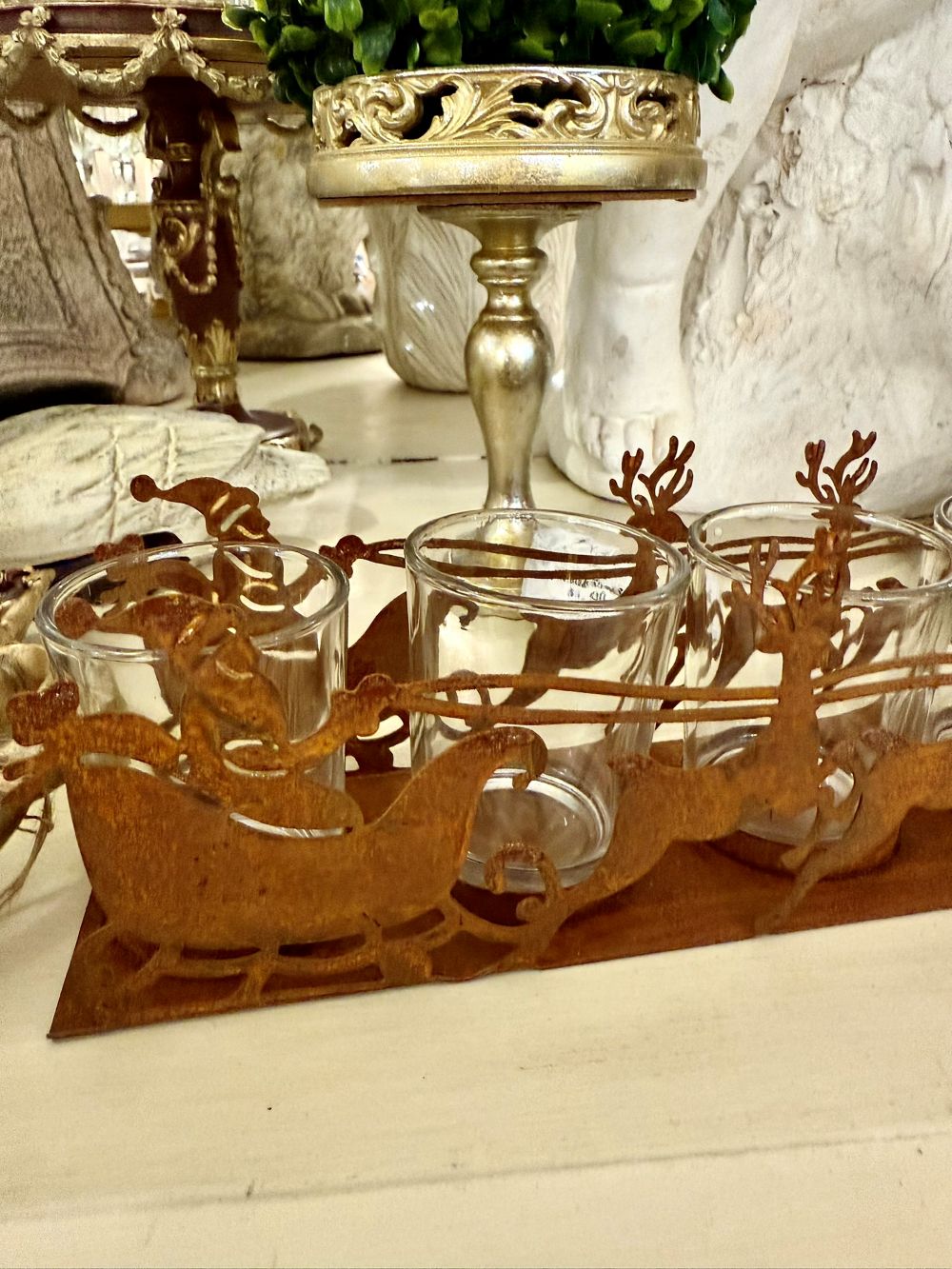 Photophore de Noël en métal rouille représentant un traîneau du Père Noël tiré par des rennes, avec 4 emplacements pour bougies chauffe-plat, style romantique et féérique