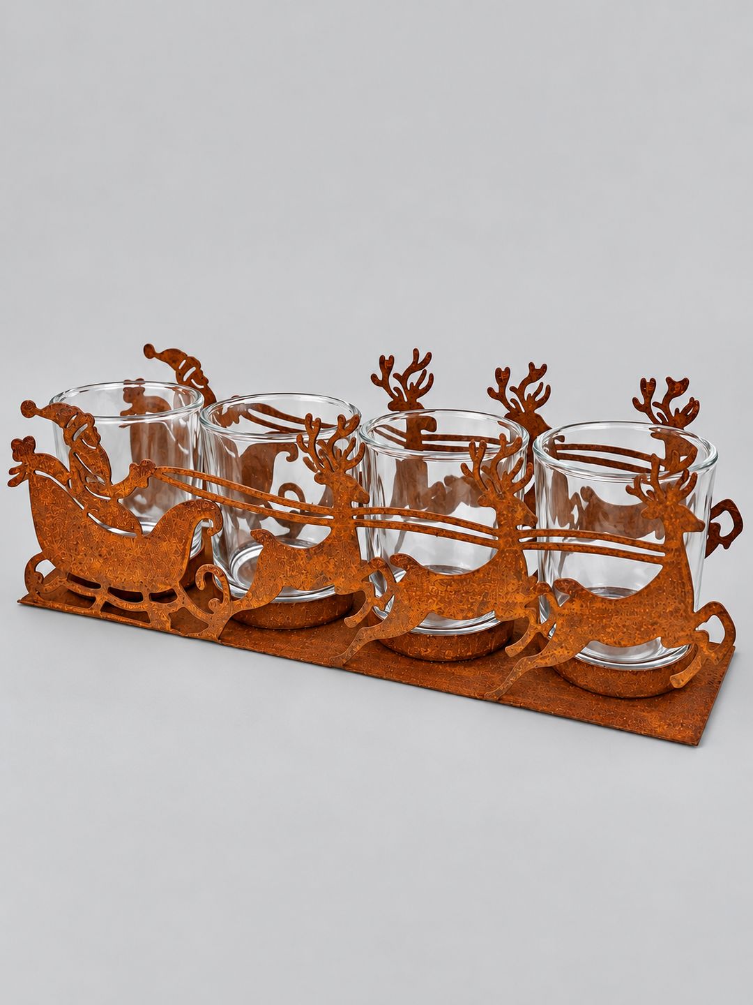 Photophore Traîneau du Père Noël en métal effet rouille, avec quatre verres transparents, présenté sur fond gris clair.