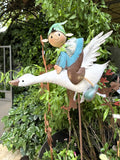 Décoration de jardin en métal représentant un lutin féérique bleu et vert sur une oie blanche en plein vol, style poétique et romantique, idéale pour un extérieur enchanteur